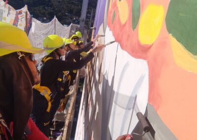 Grupo de cinco artistas pintando o mural.